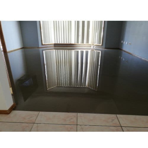 Crosbe leveller A room with a standing self-levelling compound covering the floor, reflecting light and furniture.